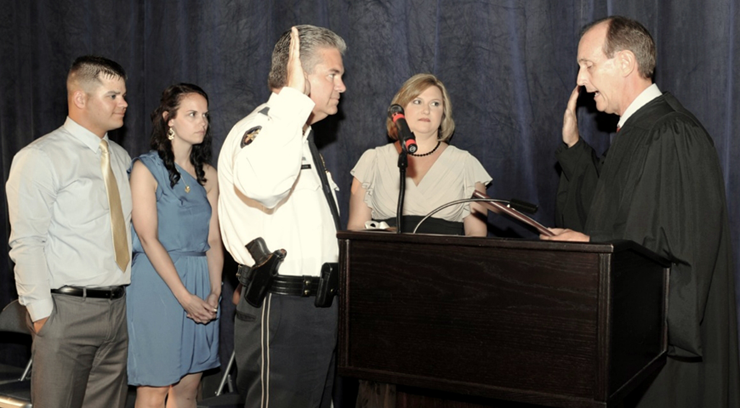 James Pohlmann, with wife, Monique next to him, as sworn in by Louisiana Supreme Court Justice John Weimer. At left is the sheriff's son, Justin and Justin's fiancée Alison Ancalade. 