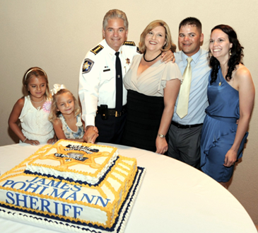 The sheriff cuts the cake at the reception following the swearing-in. With him are daughters Victoria and Olivia, wife, Monique, son Justin and Justin's fiancée Alison Ancalade. 