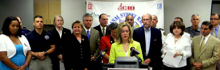 Darlene Cusanza, President and CEO of Crimestoppers Inc. which offers rewards for tips to solve crimes, announces a Sept. 22 foot race on Canal Street to help the group raise $50,000 to make up funding cuts. Behind her are numerous law enforcement officials, including Sheriff James Pohlmann, who support the effort, as well as New Orleans city officials, a crime victim’s mother and representatives of the Saints and from the New Orleans Metropolitan Association of Realtors which has donated $10,500 to cover costs of the race.