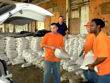 St. Bernard Parish Prison work crews, supervised by Sheriff’s Dep. Brian Cadzow,  load sandbags into vehicles at the sheriff’s sandbag barn at the rear of the Port of St. Bernard on Monday as residents took advantage of the offer to get the bags for protection of their homes and businesses.