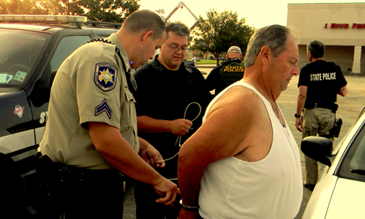 Adam Ciuffi Sr., wanted for distribution of prescription drugs, is brought to a staging area after his arrest. Shown are St. Bernard sheriff’s deputies, from left, Darren Trandacosta and Sgt. Darren Miller.