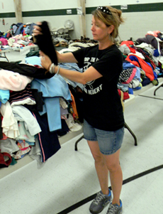  Suzanne Shaffer looks over donated clothes at Lynn Oaks School, where she discovered a burglary of  $15,000 of goods on Sunday.