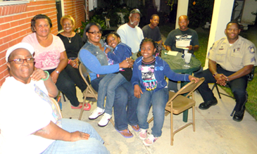 Rosetta Santiago, seated bottom left, with friends at her National Night Out Against Crime party on Guerra Drive in Violet.  At right is Sheriff's Det. Sgt. Donald Johnson, assigned to answer any questions and give crime prevention tips.