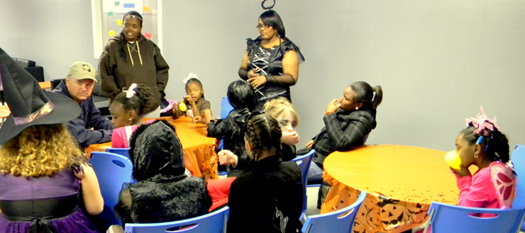 sheriff Pohlmann talks with the girls about their interests and answers questions. Standing at left is Allison Humphrey and at right, Tiara Howlett.