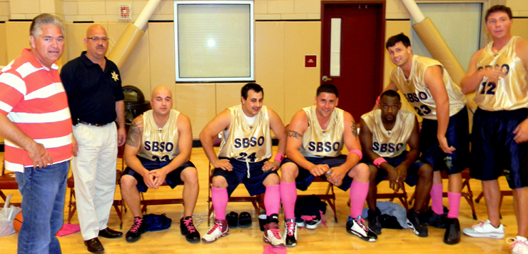 Sheriff James Pohlmann, who was on the bench throughout the game to support the Sheriff's Office team, is shown with them during a timeout. From left is the sheriff, Col. David Mowers who served as coach, while seated are deputies Brad Nuccio, Justin Topey, Ryann Laylle, Shelton Smith, and, standing are Brandon Licciardi and Jonathan Smith.