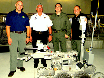 Sheriff’s Bomb Squad members are shown with the department’s bomb robot for investigating suspicious items. From left are Sgt. Chris Scheeler, Bomb Squad commander Maj. Mark Poche, Capt. Daniel Doucet and Sgt. Stephen Ingargiola. All perform other duties with the Sheriff’s Office as well as Bomb Squad operations. 