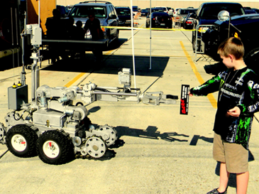 Justin Frazier from the St. Bernard community tests the sheriff's bomb robot used to check out suspicious items, in this case a D.A.R.E. anti-drug program bumper sticker the boy held. 