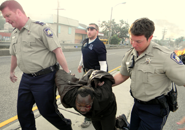 Suspect Cyprian Robertson, 37, of Chalmette, is carried away from his burning auto by by, at left, St. Bernard Sheriff's Deputy Lt. Raymond Whitfield, Louisiana Probation and Parole Agent Andrew Bodine and Deputy Jonathan Smith after Robertson fled a  Chalmette courtroom while deciding whether to accept a deal in a criminal case, then crashed and burned a car on the Industrial Canal bridge ramp in New Orleans.