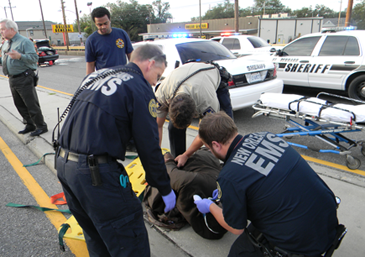 Parmamedics and firefighters treat Robertson's injuries before he is taken to a hospital. 