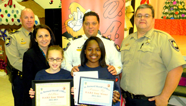 At Lynn Oaks School, D.A.R.E. essay winners were, in front, Jenna Lemoine and Shayla Green. In back are Capt. Ronnie Martin, Principal Kim Duplantier, Maj. Chad Clark and Sgt. Darrin Miller.