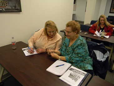 Mary Lou Lang and Marlene Stierwald look at a device Capt. Borchers demonstrated in the class. 
