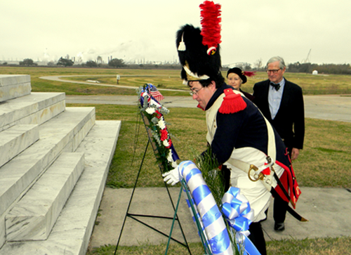 Tim Strain of Chalmette, escorting James Coleman Jr. of the British Consulate in New Orleans and Jane Caruso of the Daughters of the British Empire in Louisiana, lays a wreath at the steps of the Chalmette Monument at the end of the ceremony. 