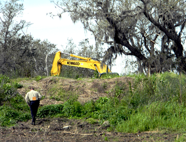 An excavating machine, borrowed from St. Bernard Parish government, is shown digging up an area where a man's body was recovered Tuesday about 75 yards off Florissant Highway, on the road to the Yscloskey, Shell Beach and Hopedale areas in eastern St. Bernard, New Orleans police said they had received information a man had been killed in the city last summer and buried in St. Bernard. St. Bernard's Sheriff's Office assisted in the operation.