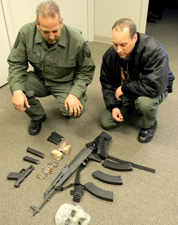 Two St. Bernard sheriff's detectives working the Johnson case, Det. Capt. Mark Jackson, left, and Det. Michael Schiro, with the mask and small arsenal of guns and magazines found in Johnson's car after his arrest. 