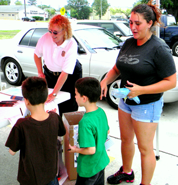 Two youngsters pick out pencils, key chains, coloring books and other items the Sheriff's Office gave out to children during the drug take-back effort.