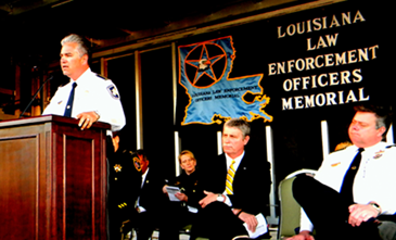 Sheriff James Pohlmann addresses the crowd from the podium. Seated to his left are former U.S.Attorney Jim Letten and New Orleans Police Superintendant Ronal Serpas. 