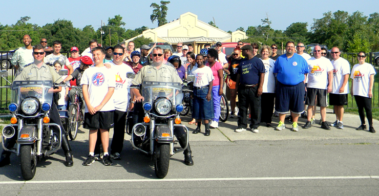 Sheriff's deputies, intellectually challenged adult associates from Arc and others begin the Torch Run for Special Olympics, leaving the Arc center grounds.