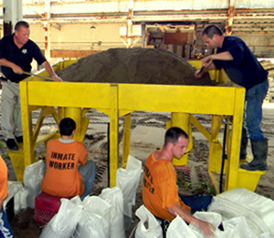 Sheriff's Dep. Brian Cadzow, left, helps trusty prisoners make sandbags in preparation for hurricane season.