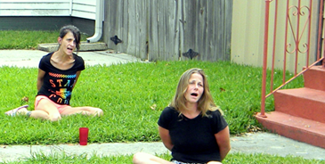 Suspects Rachel Butler, in foreground, and Melissa Huy, in background, both of Chalmette, are handcuffed and sitting on the ground outside Huy’s home after their arrests late Wednesday afternoon.