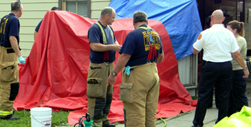 St. Bernard firefighters put up a makeshift tent and provided water to decontaminate children and the suspects involved in the meth lab operation.