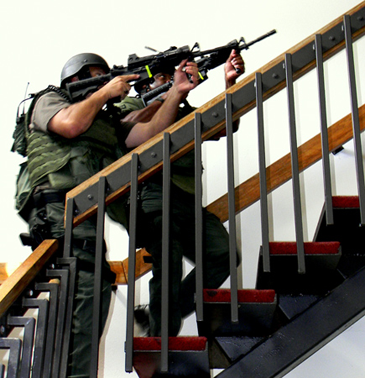 Sheriff’s SWAT team members climb a stairwell as they train at Lynn Oaks School in eastern St. Bernard.