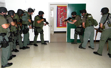 Officers prepare to enter a school hallway.