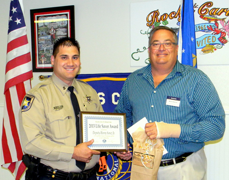 Dep. Sheriff Henry Senez Jr. is presented the St. Bernard Kiwanis Club Life-Saver Award by Mitch Perkins of the club.