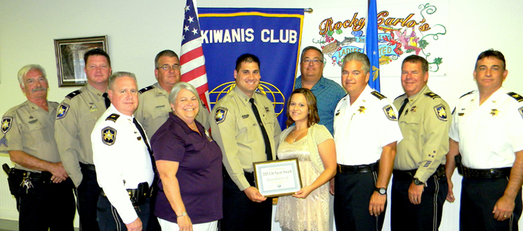 Dep. Henry Senez Jr. holds the Kiwanis Life-Saver Award with his wife, Melissa, to his left, and they are surrounded by sheriff's deputies and club officials. From left in the front row are Maj. Adolph Kreger, Kiwanis member Shirley Pechon, Senez and wife, Sheriff James Pohlmann, Capt. C.J. Arcement and Col. John Doran. In back, from left, are Sgt. Dick Beebe, Lt. Ray Whitfield, Lt. Robert Broadhead and Kiwanis member Mitch Perkins.