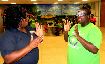 Demonstrating distraction glasses which simulate the effect on a person impaired by drinling or using drugs, Sheriff's D.A.R.E. program head Lt. Lisa Jackson, left, tests the coordination skills of Nina Varnado, camp director, who is wearing the glasses.