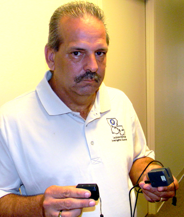 St. Bernard Parish Sheriff's Office Det. Capt. Mark Jackson holds two skimmers recovered in the arrests Friday of Spears and Tate.