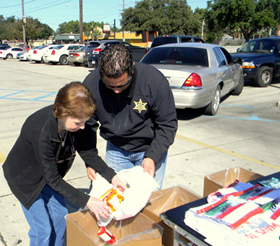 Carolyn Kimball of Meraux and Maj. Chad Clark empty a bag of medicatioms she brought into a collection box.