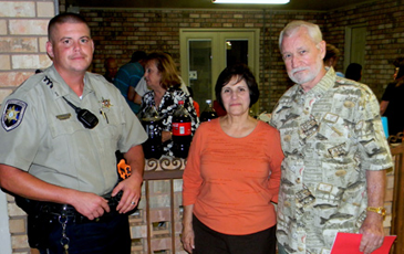 Sheriff’s Deputy Jules Henry with Carol and Al Beaubouef at their party in the Lexington Place subdivision in Meraux.