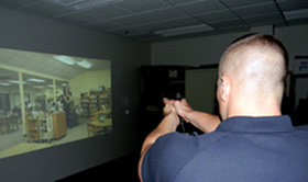 Sheriff’s deputy Daniel Bostic looks as a video, prepared toi fire, as he does refresher training on the firearms simulator that was loan to the Sheriff’s Office from the state Attorney General’s office.