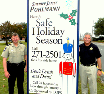 Signs telling the public about the free Holiday Ride Home program have been put up around St. Bernard. Shown at one is Sheriff James Pohlmann, at right, with Lt. Brent Bourgeois of the Traffic Division.