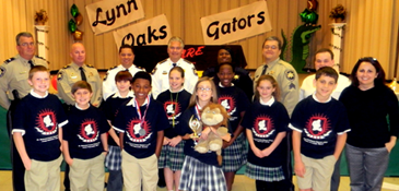 At Lynn Oaks School, in the front, from left, are essay runner-up Barry Alexis and winner Tori Mire; behind them students Cayden Lepine, Kobie Tremblay, Tori Baudot, Tatum Miller, Robyn Polk, Nanon Dean, Christian Moore and Principal Kim Duplantier. In back are Lt, Robert Broadhead, Capt. Ronnie Martin, Maj. Chad Clark, Sheriff James Pohlmann, Lt. Lisa Jackson, sgt. Darrin Miller and teacher Chris Wilder Jr.