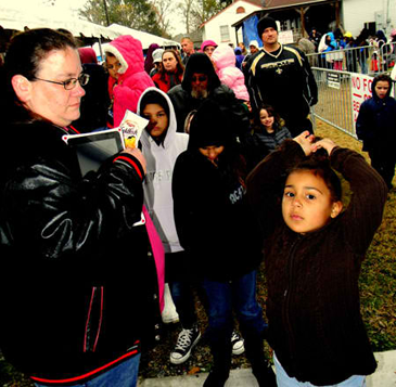 A large crowd waits in line outside to enter the building to meet with Santa, Mrs. Claus and their elves. 