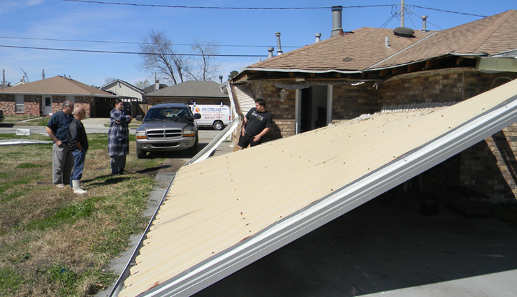 Residents in the 2200 block of Judy Drive look at a patio cover that was torn from a home and blown down.