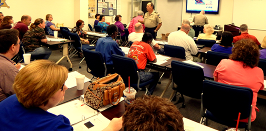Capt. Charles Borchers in front of a large audience of participants at the Citizens Police Academy class.