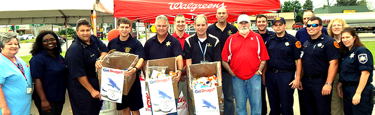 Sheriff James Pohlmann, Walgreens store manager Charles Mengel and several parish firefighters hold up boxes of prescription drugs turned in by the public at a drug take-back day held at Walgreens on Saturday, Sept. 27. Other Wa;greens emp;pyees, sheriff's depties and firefighters surround them.