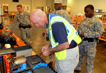 Lt. Raymond Theriot, deputy director of training for the St. Bernard Sheriff's Office, helps Guardsmen with weapons safety checks for the active shooter simulation drill.