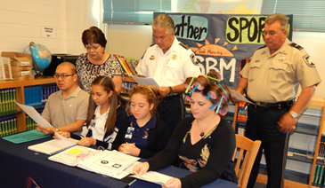 Sheriff James Pohlmann participated with St. Bernard Middle School students on Wednesday in the national student pledge against gun violence. Taking part in a live message shown to all homerooms in the school are, from left in front, school counselor Paul Tran, 8th-grade students Madison Melerine and Brissa Taylor and Assistant Principal Angela Seibert, who was also participating in Crazy Hair Week at the school. In back are Principal Sue Deffes, Sheriff Pohlmann and Lt. Robert Broadhead.