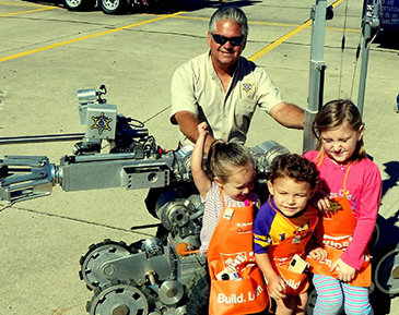 Sheriff James Pohlmann, with Olivia Cavalier, Noah Wagner and Isabelle Lulei, who are sitting on the sheriff's bomb robot, used to check out suspicious items to see if they contain an explosive.device.