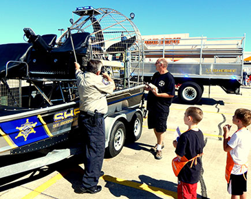 Capt. Gerald Kimble, left, shows the Sheriff's Office airboat to, from left, Jace Landry of Chalmette and Nathan Scallan of Chalmette, with Stanley Scallan at right.